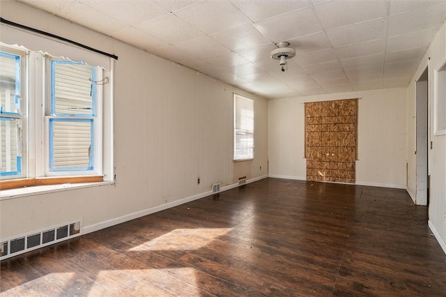unfurnished room with visible vents, baseboards, and wood finished floors