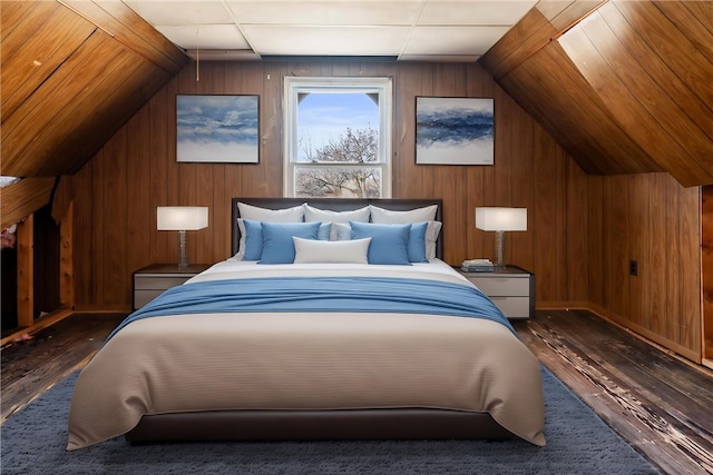 bedroom featuring hardwood / wood-style floors, wood walls, and vaulted ceiling