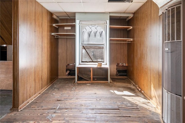 interior space featuring hardwood / wood-style floors, wood walls, and a heating unit