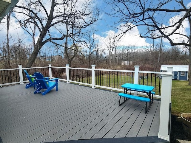 wooden terrace featuring a storage shed, an outdoor structure, and a lawn