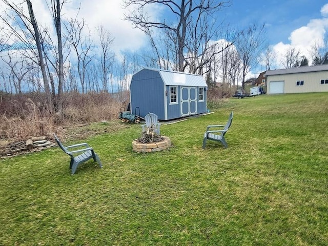 view of yard featuring an outdoor structure, an outdoor fire pit, and a storage unit