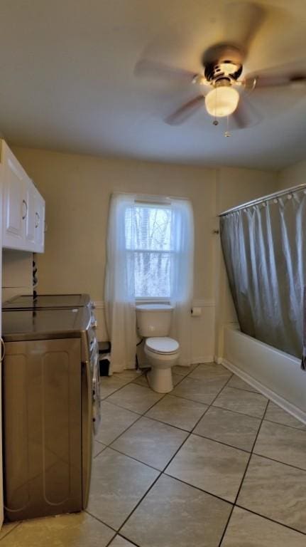full bathroom with tile patterned floors, toilet, washer / dryer, and a ceiling fan