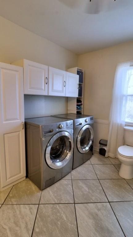 laundry area with laundry area, separate washer and dryer, light tile patterned floors, and baseboards