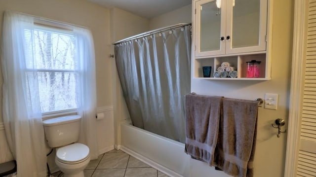 full bathroom with tile patterned floors, shower / tub combo with curtain, and toilet