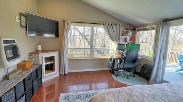 bedroom with access to outside, vaulted ceiling, wood finished floors, baseboards, and heating unit