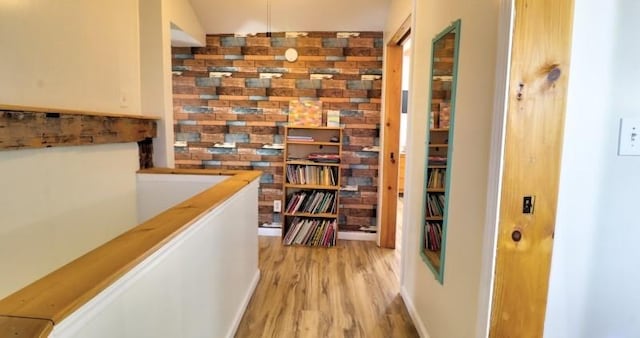 corridor with an upstairs landing and light wood finished floors