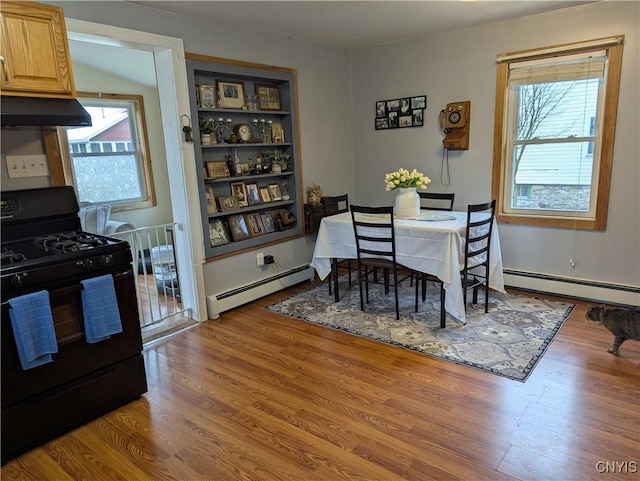 dining room with a baseboard radiator and wood finished floors