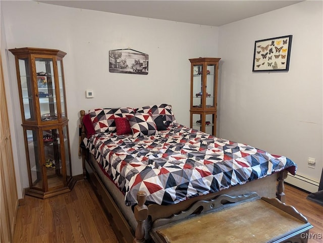 bedroom featuring a baseboard radiator and wood finished floors