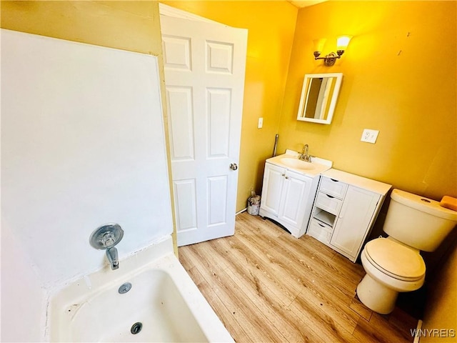 99 Roebling Ave, Buffalo, NY 14215 - bathroom with a tub to relax in, vanity, toilet, and wood finished floors