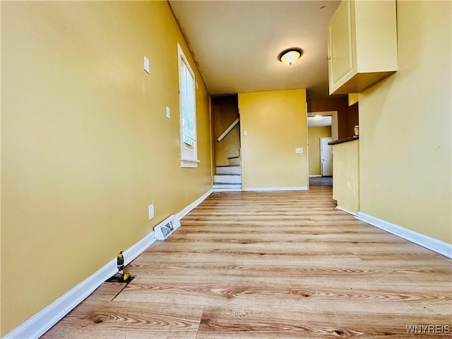 99 Roebling Ave, Buffalo, NY 14215 - unfurnished living room featuring light wood-type flooring, baseboards, and stairs