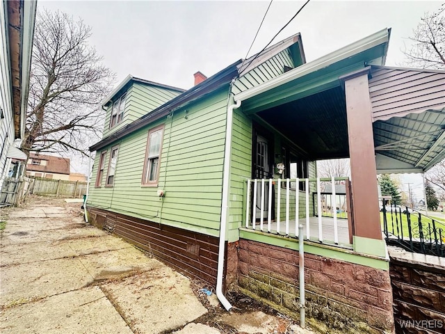 99 Roebling Ave, Buffalo, NY 14215 - view of property exterior with fence, a porch, crawl space, and a chimney