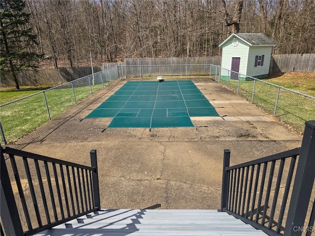 view of pool featuring an outbuilding and a fenced backyard