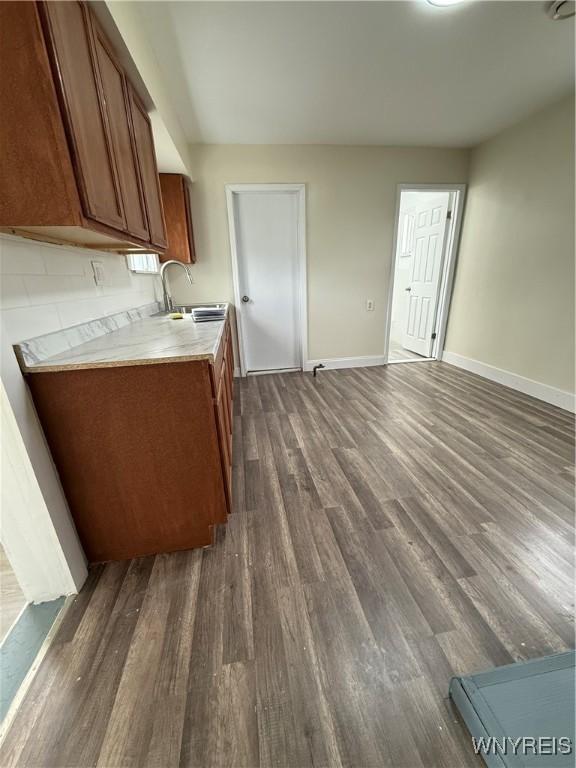 72 Person St, Buffalo, NY 14212 - kitchen featuring brown cabinetry, dark wood-style flooring, a sink, light countertops, and baseboards