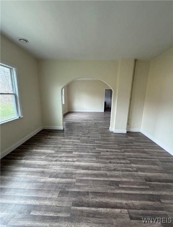72 Person St, Buffalo, NY 14212 - spare room featuring arched walkways, dark wood-style flooring, and baseboards