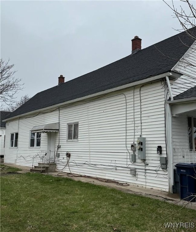 72 Person St, Buffalo, NY 14212 - back of property featuring a yard, a shingled roof, and a chimney