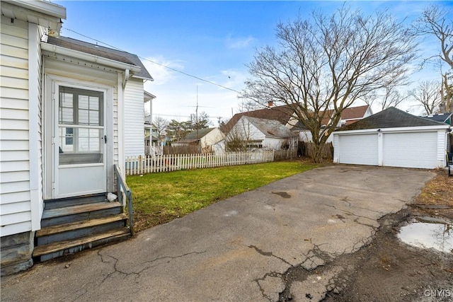 view of yard featuring entry steps, an outdoor structure, fence, and a detached garage