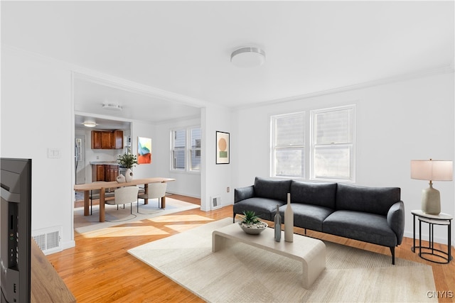 living area with a wealth of natural light, light wood-style floors, and baseboards