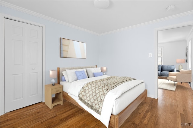 bedroom with ornamental molding, a closet, and wood finished floors