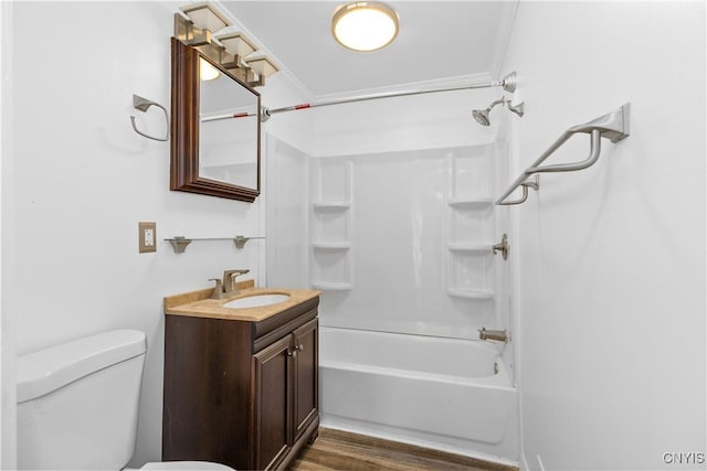 bathroom featuring toilet, bathing tub / shower combination, wood finished floors, and vanity