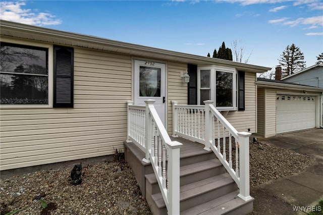entrance to property with an attached garage and concrete driveway