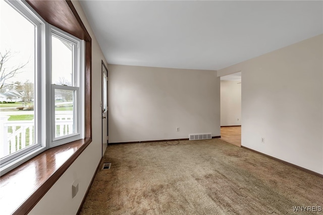 spare room featuring visible vents, a wealth of natural light, and carpet floors