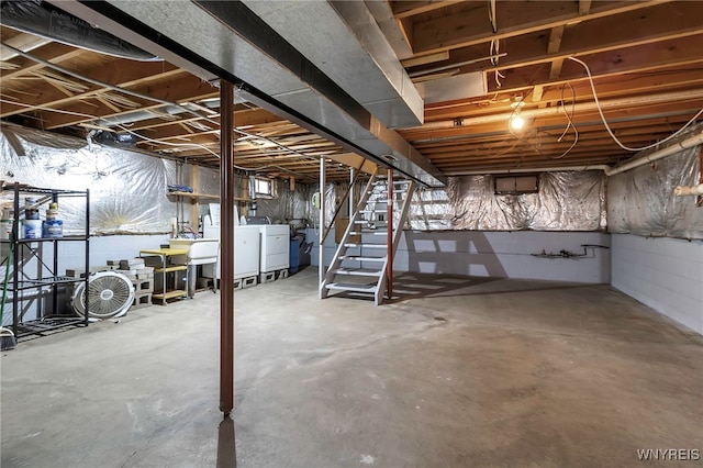unfinished basement featuring stairway and washer and clothes dryer