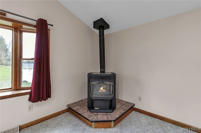 details with visible vents, a wood stove, carpet, and baseboards