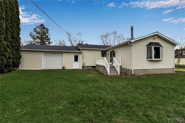 rear view of house featuring an attached garage, a wooden deck, and a lawn