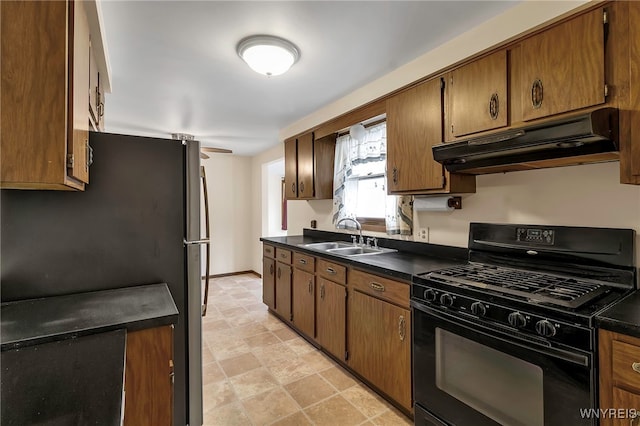 kitchen featuring a sink, dark countertops, black gas stove, and under cabinet range hood