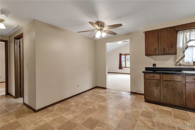 kitchen featuring dark countertops, dark brown cabinets, baseboards, and a ceiling fan