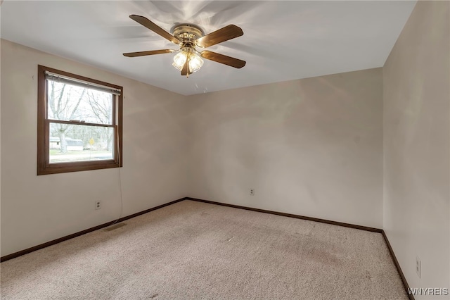 carpeted empty room with visible vents, baseboards, and ceiling fan