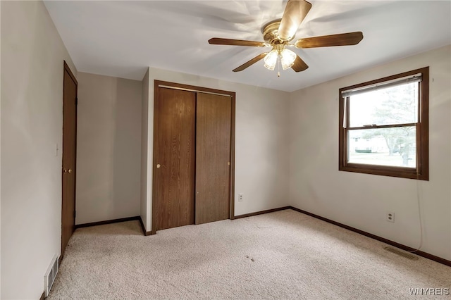 unfurnished bedroom featuring baseboards, visible vents, a closet, and light colored carpet
