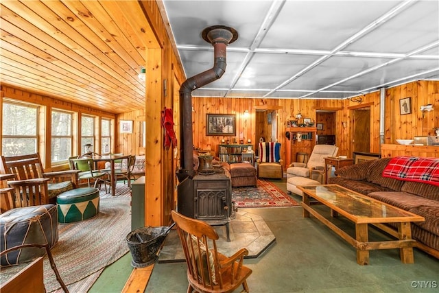 172 Green St, Ephratah, NY 13452 - living room with wood walls, a wood stove, and concrete flooring