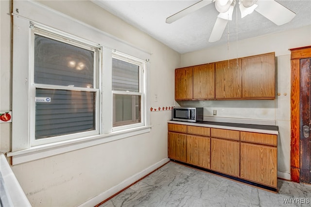 43 Freund St, Buffalo, NY 14211 - kitchen with stainless steel microwave, brown cabinets, marble finish floor, and baseboards
