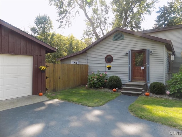 view of front of property featuring driveway, fence, and a garage