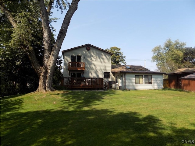 rear view of property featuring a deck, a yard, and a balcony