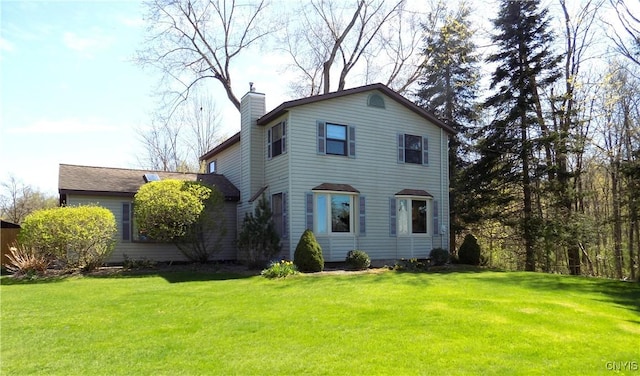 view of front of house featuring a chimney and a front lawn