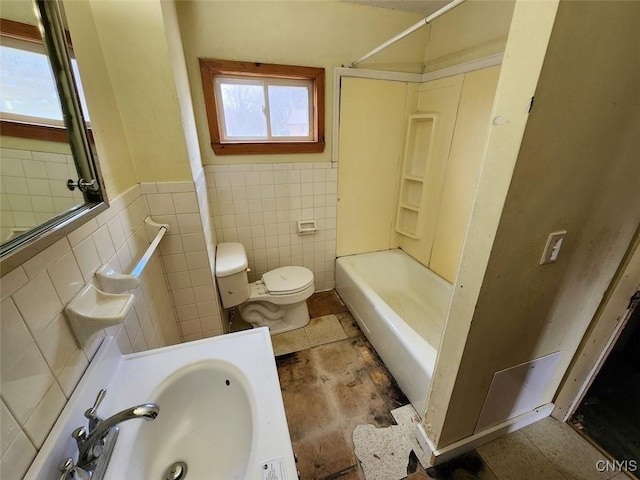 bathroom featuring  shower combination, toilet, a sink, wainscoting, and tile walls