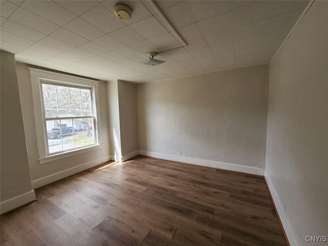 unfurnished room featuring baseboards and wood finished floors