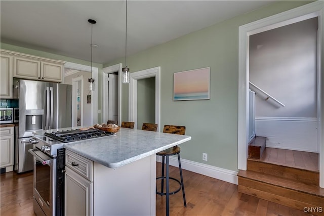 11853 State Route 12e, Lyme, NY 13622 - kitchen featuring dark wood-style floors, a center island, decorative light fixtures, a breakfast bar area, and stainless steel appliances