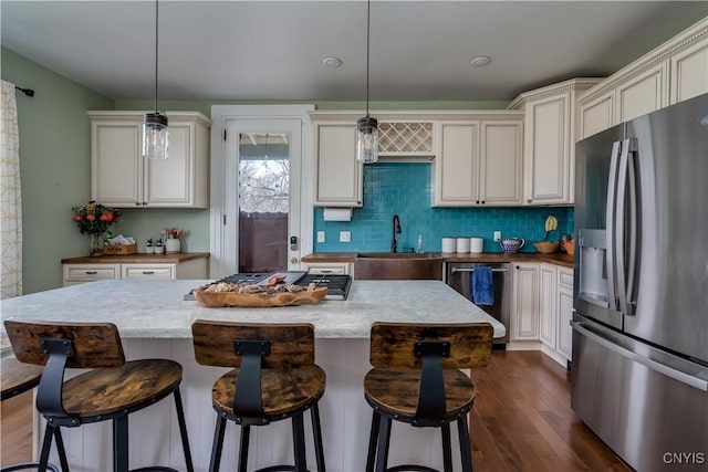 11853 State Route 12e, Lyme, NY 13622 - kitchen with tasteful backsplash, dark wood-style flooring, a sink, hanging light fixtures, and stainless steel appliances