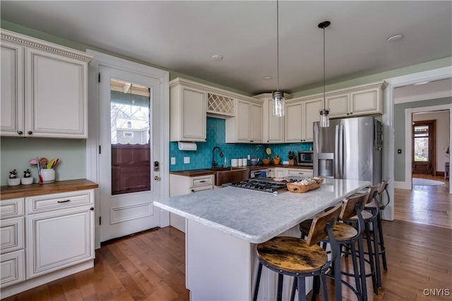 11853 State Route 12e, Lyme, NY 13622 - kitchen featuring pendant lighting, dark wood-type flooring, a breakfast bar, a sink, and stainless steel appliances