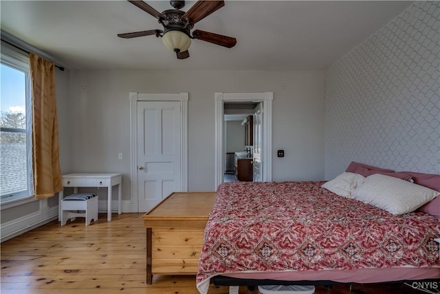 11853 State Route 12e, Lyme, NY 13622 - bedroom featuring light wood finished floors, an accent wall, multiple windows, and wallpapered walls