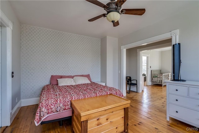 11853 State Route 12e, Lyme, NY 13622 - bedroom featuring light wood-style flooring, wallpapered walls, an accent wall, and baseboards