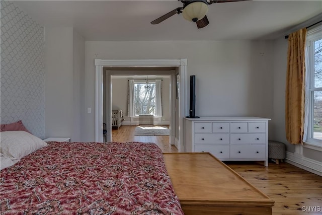 11853 State Route 12e, Lyme, NY 13622 - bedroom featuring baseboards, an accent wall, light wood-style floors, and wallpapered walls