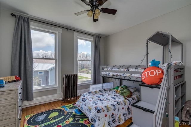 11853 State Route 12e, Lyme, NY 13622 - bedroom featuring baseboards, a ceiling fan, radiator, and light wood-style floors