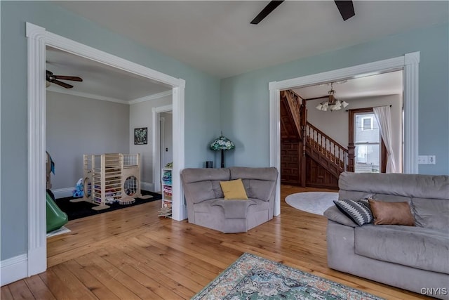 11853 State Route 12e, Lyme, NY 13622 - living room with baseboards, ornamental molding, stairs, hardwood / wood-style flooring, and ceiling fan with notable chandelier