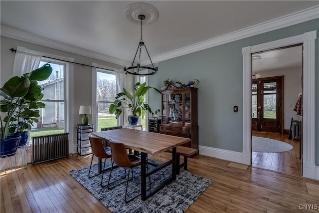 11853 State Route 12e, Lyme, NY 13622 - dining room featuring crown molding, light wood-style flooring, radiator heating unit, a notable chandelier, and baseboards