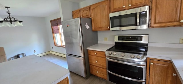 kitchen featuring a chandelier, light wood-type flooring, appliances with stainless steel finishes, and light countertops