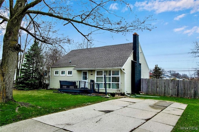 4757 N Bailey Ave, Amherst, NY 14226 - rear view of property featuring fence, a shingled roof, a lawn, and a chimney